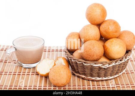 buñuelos cibo tradizionale colombiano; pane fritto di formaggio e cioccolata calda bevanda, foto su sfondo bianco Foto Stock