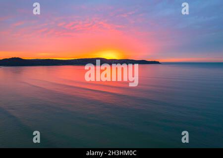 Colorata alba coperta da nuvole a Umina Beach sulla costa centrale, NSW, Australia. Foto Stock