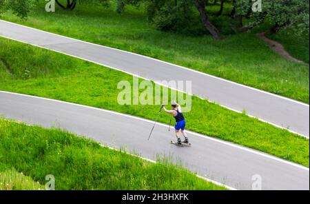 Un uomo su uno sciatore corre su una pista in una giornata estiva di sole Foto Stock