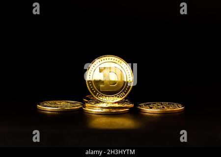 Alcuni Dogecoins che hanno un colore oro sono attualmente popolari e hanno un valore crescente rispetto al dollaro US. Per pagamenti, finanziamenti, investimenti a Foto Stock