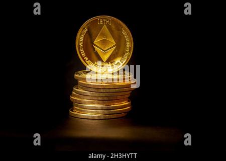 Un mucchio di monete Ethereum che hanno un colore oro che è attualmente popolare e ha un valore crescente rispetto al dollaro statunitense. Per il pagamento, il finanziamento, Foto Stock