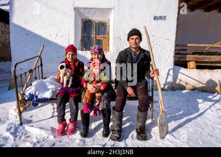 Una famiglia posa per una fotografia di fronte alla loro casa ad Asra, Nurata, Uzbekistan Foto Stock
