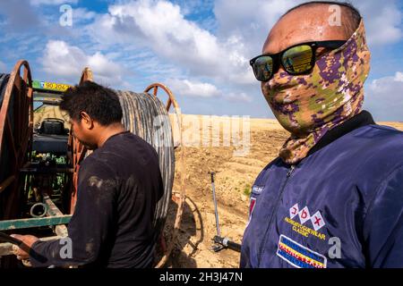 Lavoratori dalla Thailandia che lavorano con macchinari sul Kubbutz Alumim nel deserto di negev, nel sud d'Israele Foto Stock