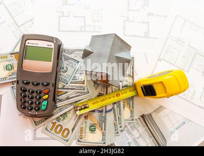 Soldi contro lo sfondo della disposizione della casa. Stipendio per i costruttori. Posti vacanti per i costruttori. Formazione nelle professioni di costruzione. Foto Stock