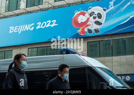 I pedoni camminano davanti ad un negozio di merchandising autorizzato per le Olimpiadi invernali del 2022 a Pechino, Cina. 29 ottobre 2021 Foto Stock