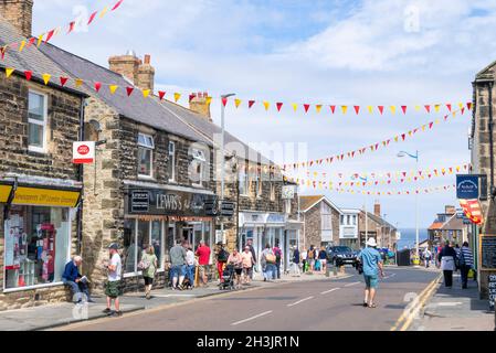 I turisti che si dedicano allo shopping nella strada principale hanno scoperto il bunging attraverso Seahouses Northumberland England UK GB Europe Foto Stock