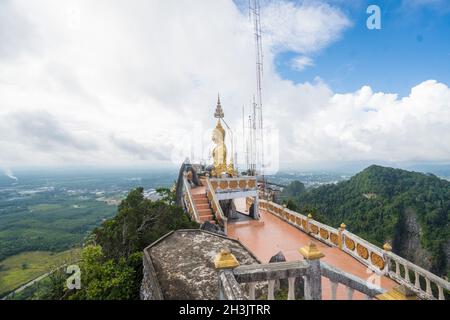 Grande statua del Buddha d'oro contro il cielo nuvoloso nel tempio della Thailandia Foto Stock