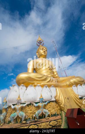 Grande statua del Buddha d'oro contro il cielo blu nel tempio della Thailandia Foto Stock