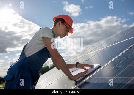 Vista laterale su worker e pannello solare. Foto Stock