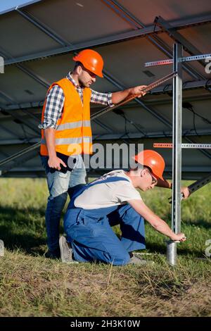 Costruttori di installare il telaio con pannelli solari sul palo elicoidale. Foto Stock