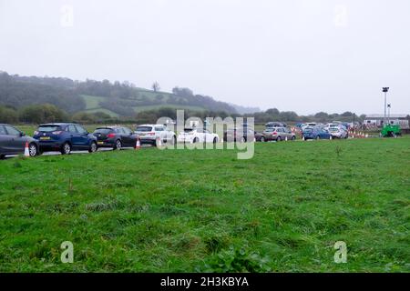 Le persone che si accingono in fila coda di auto per ottenere coronavirus Pfizer Covid vaccinazioni booster jab presso il centro di test di Carmarthen showground nel Galles UK Foto Stock