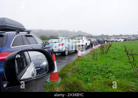 Le persone che si accodano in fila coda di auto per ottenere coronavirus Pfizer Covid vaccinazione richiamo jab presso il centro di test di Carmarthen showground nel Galles UK Foto Stock