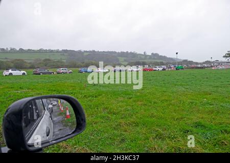 Le persone che si accingono in fila coda di auto per ottenere coronavirus Pfizer Covid vaccinazioni booster jab presso il centro di test di Carmarthen showground nel Galles UK Foto Stock