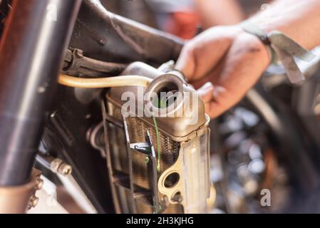 Meccanico motociclista, sostituzione del radiatore di raffreddamento. Sostituzione o manutenzione del radiatore. Foto Stock