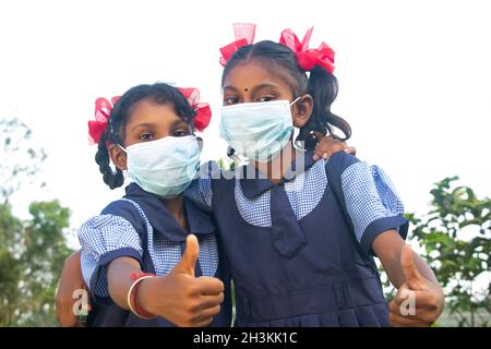 Donna del villaggio che brucia i capelli della sua figlia che va della scuola seduta su una culla nella loro casa Foto Stock