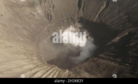 Vista aerea cinematografica del cratere del Monte bromo con fumo attivo del vulcano a Giava Est Foto Stock