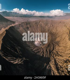 Vista aerea cinematografica del cratere del Monte bromo con fumo attivo del vulcano a Giava Est Foto Stock