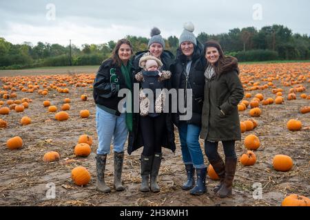 Cookham, Berkshire, Regno Unito. 29 ottobre 2021. Charlie Curtis, Emily e il bambino Isabella Leigh, o’Mahony e Jane Curtis (da L a R). Nonostante la pioggia e il vento, i bambini e le loro famiglie stavano godendo le vacanze scolastiche preparandosi per Halloween raccogliendo le zucche coltivate alla fattoria Copas a Cookham, Berkshire. 25,000 zucche sono state coltivate in azienda quest'anno per la prima volta. Credit: Maureen McLean/Alamy Live News Foto Stock