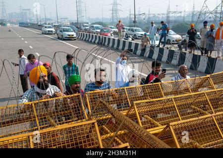 New Delhi, India. 29 ottobre 2021. Gli agricoltori guardano mentre la polizia di Delhi inizia a rimuovere le barricate dal confine di Nuova Delhi-Uttar Pradesh a Ghazipur, Nuova Delhi.migliaia di agricoltori hanno protestato contro il Ghazipur, Tikri, Singhu e confini nella parte esterna e orientale di Delhi contro tre leggi agricole da novembre scorso. I blocchi sono stati messi in atto a seguito della violenza durante il raduno della festa della Repubblica degli agricoltori. Credit: SOPA Images Limited/Alamy Live News Foto Stock