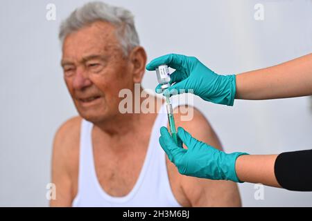 Monaco di Baviera, Germania. 29 ottobre 2021. Foto topica vaccinazione di richiamo per gli uomini di oltre sessant'anni (92 anni) con la sua terza vaccinazione (foto simbolo). Vaccinazione, richiamo, siringa di vaccinazione, siringa, vaccino per iniezione con ago. Modello rilasciato! Credit: dpa/Alamy Live News Foto Stock