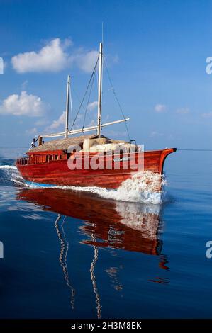 Tradizionale Dhoni vela a velocità nell'Atollo Sud Ari nelle Maldive, Oceano Indiano. Foto Stock