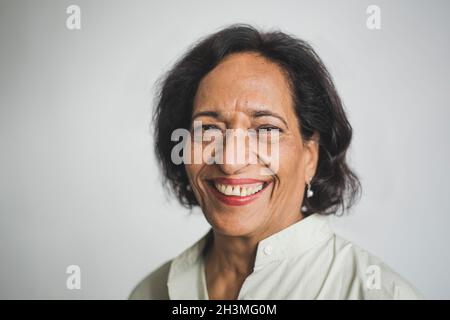 Ritratto di donna anziana sorridente contro il muro Foto Stock