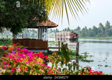 Navigando a un ritmo piacevole si trova una casa galleggiante di paglia conosciuta localmente come Kettuvallam sulle pittoresche e tranquille acque del Kerala state nel sud Foto Stock