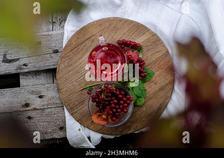 una tazza di tè con viburnum su un asse di legno chiaro tovaglia vista dall'alto Foto Stock