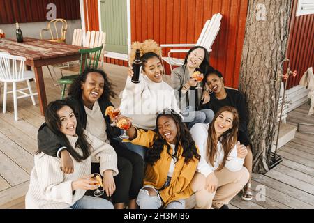 Ritratto ad alto angolo di amici femminili che si divertono a bere al party Foto Stock