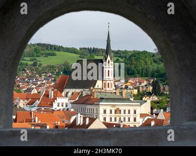 Vista di Cesky Kromlov dalla passeggiata Castello: Immagine della città di Cesky Krumlov e la Chiesa di San Vito incorniciata da uno degli archi dal passaggio del castello. Foto Stock