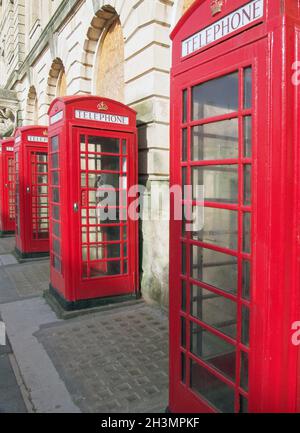 Una linea di tradizionali cassette telefoniche pubbliche rosse britanniche al di fuori dell'ex ufficio postale di Blackpool Lancashire Foto Stock