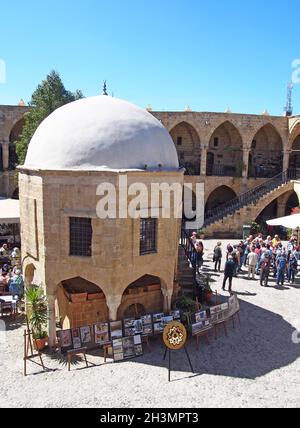 Un gruppo di turisti nel vecchio souk di Nicosia Cipro circondato da negozi e caffè Foto Stock