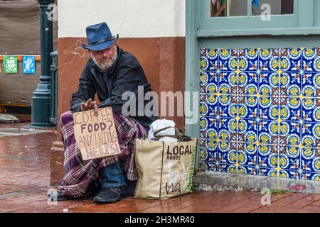 Un maschio di mezza età implora il suo cartoncino di registrazione di fronte a un negozio. Foto Stock