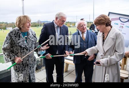 Limerick, Irlanda. 29 ottobre 2021. Il presidente federale Frank-Walter Steinmeier (2° da sinistra) e sua moglie Elke Büdenbender (r) visitano l'Università di Limerick insieme a Michael D. Higgins, presidente d'Irlanda, e sua moglie Sabina Higgins e imparano a conoscere lo sport dalle squadre di hurling dell'Università di Limerick. Il Presidente Steinmeier e sua moglie sono in visita di Stato di tre giorni in Irlanda. Credit: Bernd von Jutrczenka/dpa/Alamy Live News Foto Stock