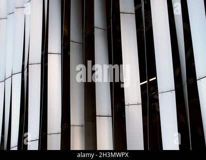 Moderni ed eleganti pannelli curvati verticali in acciaio con rivestimento esterno a motivi verticali Foto Stock