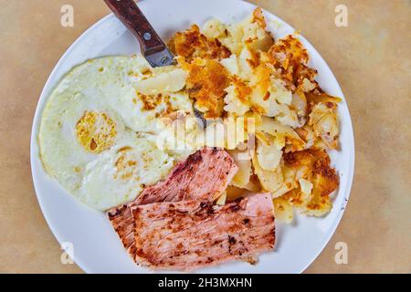 Semplice piatto per la colazione con vista verso il basso con prosciutto, uova e patate Foto Stock