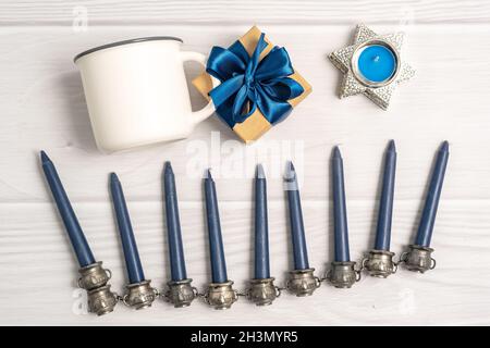 Mug bianco mock-up con Hanukkah menorah, confezione regalo e candele Foto Stock