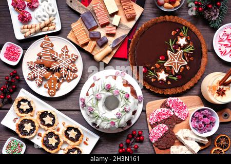 Varietà di dolci e dolci natalizi. Sopra visualizzare la scena della tabella su uno sfondo di legno. Torta Bundt, torta al cioccolato, crostate di carne macina, biscotti, Foto Stock