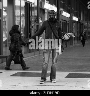 Milano, Italia; 23 marzo 2011: Immigrati che vendono giornali per strada. Foto Stock
