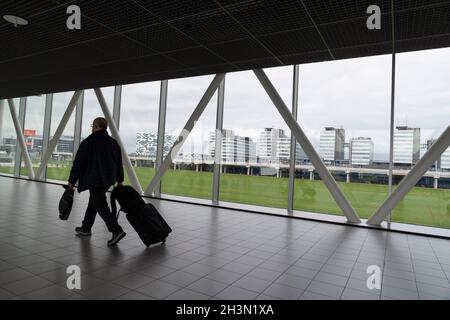 Un passeggero cammina lungo il Concourse B nell'aeroporto di Amsterdam Schiphol, nei Paesi Bassi. Foto Stock