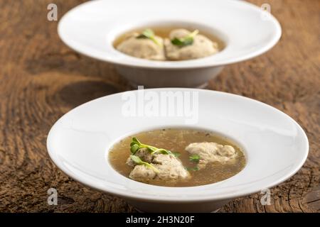 Gnocchi di carne bavaresi in brodo su legno Foto Stock