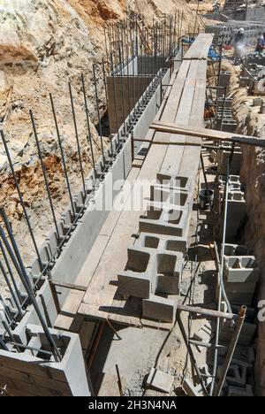 Costruzione di un nuovo muro di contenimento strutturale su un cantiere collinare Foto Stock