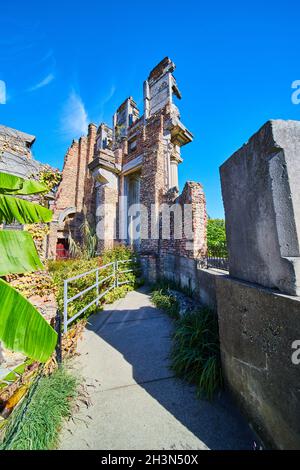 Passerella che porta a vecchi mattoni e rovine di pietra Foto Stock