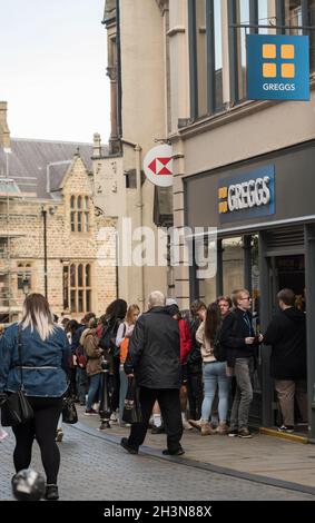 Persone che fanno la fila fuori dal negozio di panetteria Greggs nella città di Durham Inghilterra Regno Unito Foto Stock