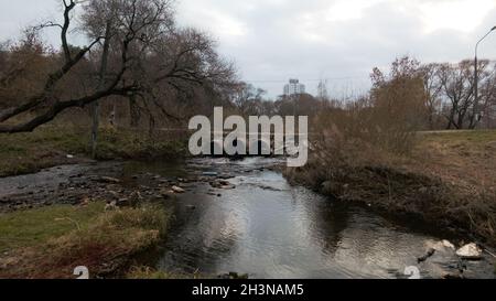 Tubi per rifiuti in calcestruzzo. Flussi di acqua fluiscono attraverso tubi di calcestruzzo. Corpo inquinato di acqua nel parco. Tiro dal drone. Fotografia aerea. Foto Stock