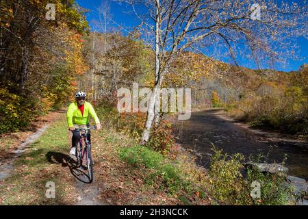 Martinton, West Virginia - John West, 75, biciclette sul Greenbrier River Trail. Il percorso ferroviario di 78 km costeggia il fiume Greenbrier. Ora è lineare Foto Stock