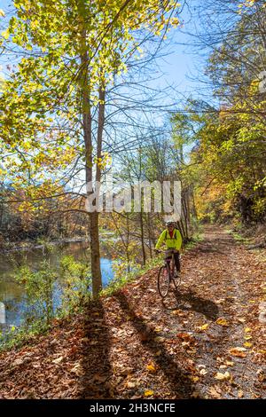 Martinton, West Virginia - John West, 75, corre in bicicletta sul Greenbrier River Trail. Il percorso ferroviario di 78 km costeggia il fiume Greenbrier. Ora Foto Stock