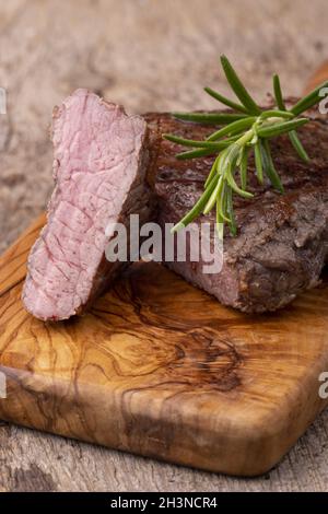 Bistecca alla griglia su legno con rosmarino Foto Stock