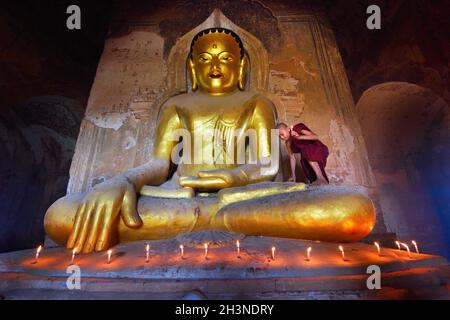 Bagan, Myanmar - 7 settembre: Giovane monaco buddista che sale sulla statua del Buddha d'oro all'interno del vecchio tempio pagoda nel parco storico di mandalay. 7 settembre 2 Foto Stock