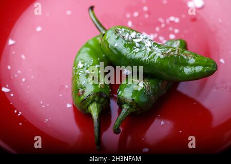 Padron Peppers auf rotem Teller Foto Stock